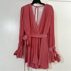 V neckline, long sleeves, and a tie belt at the waist.